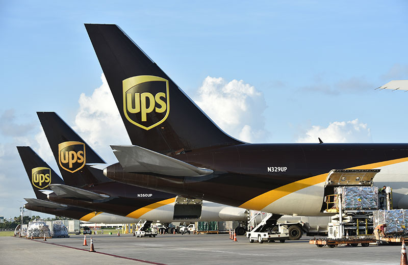 کارگران جت‌های باربری United Parcel Service Inc. (UPS) را در تأسیسات طبقه‌بندی آمریکای لاتین و کارائیب در فرودگاه بین‌المللی میامی در میامی، فلوریدا، ایالات متحده، در روز جمعه، 5 اوت 2016، تخلیه می‌کنند. بزرگترین شرکت تحویل بسته در جهان آسیب‌پذیر است. به تغییرات اقتصادی جهانی، اما در سه ماهه اخیر برخی از قوی ترین عملکرد خود را در خارج از کشور شاهد بوده است.در ایالات متحده، افزایش خریدهای آنلاین تقاضا برای خدمات حمل و نقل را افزایش می دهد.عکاس: مارک الیاس/ بلومبرگ
